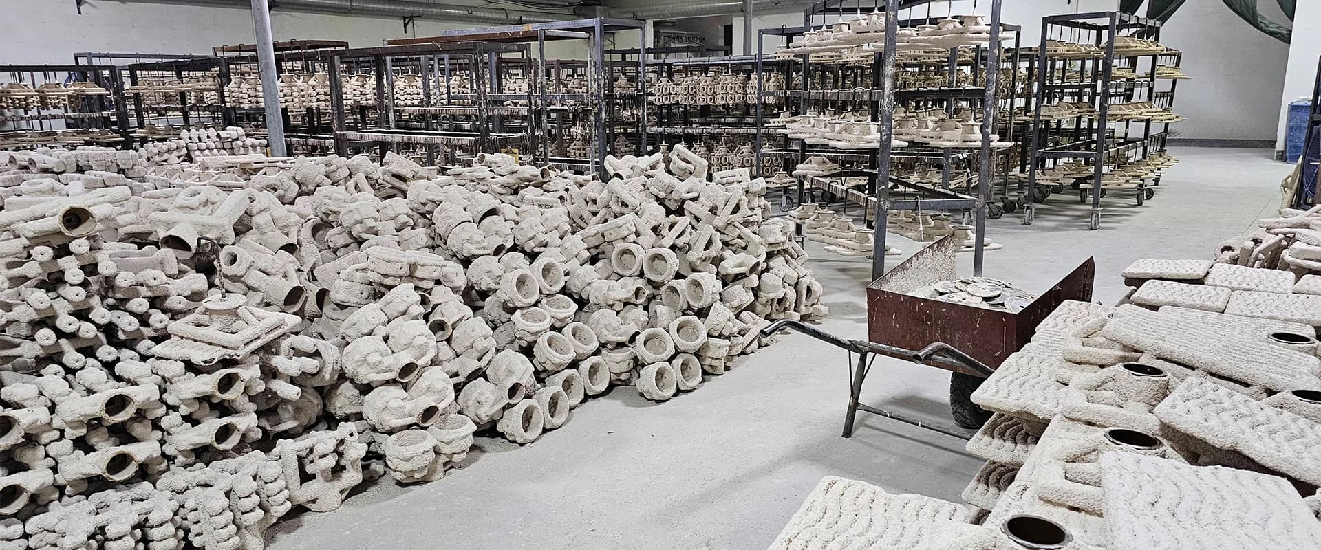 Ceramic shell molds and drying racks in the investment casting workshop