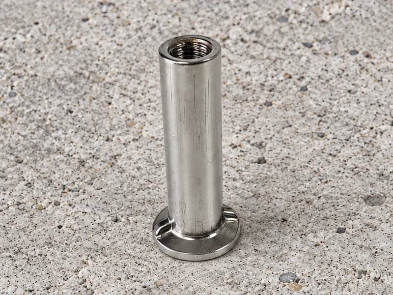 Cylindrical internally threaded ferrule with a round flanged foot and local ribs at the base